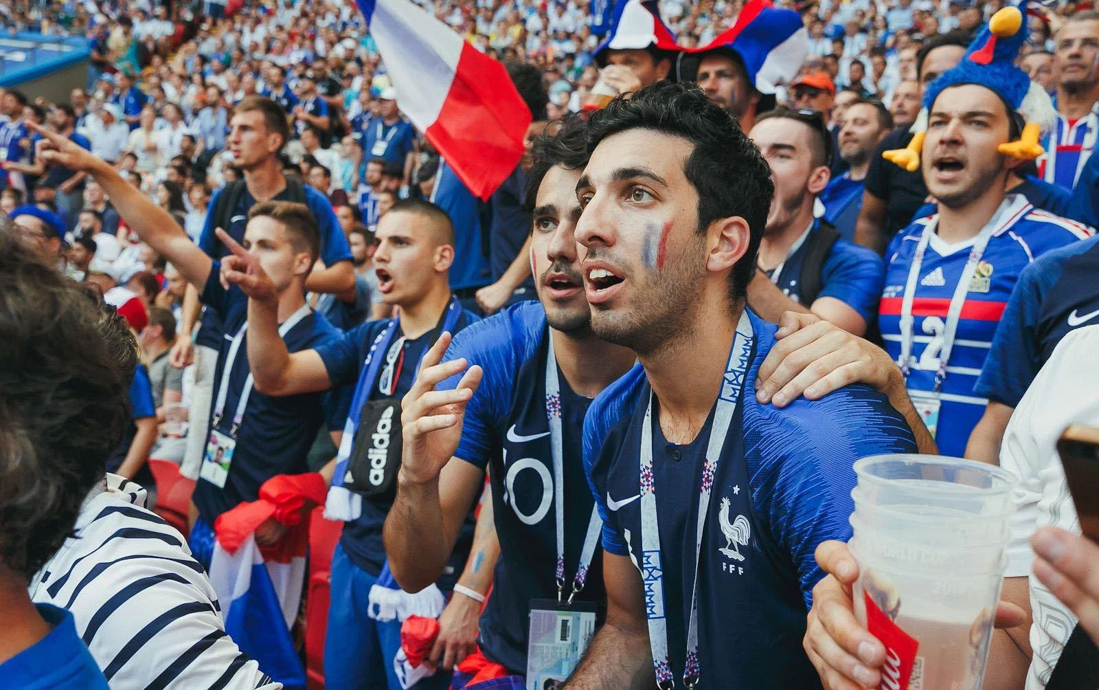 Football supporters wearing tournament identification in a crowded stadium