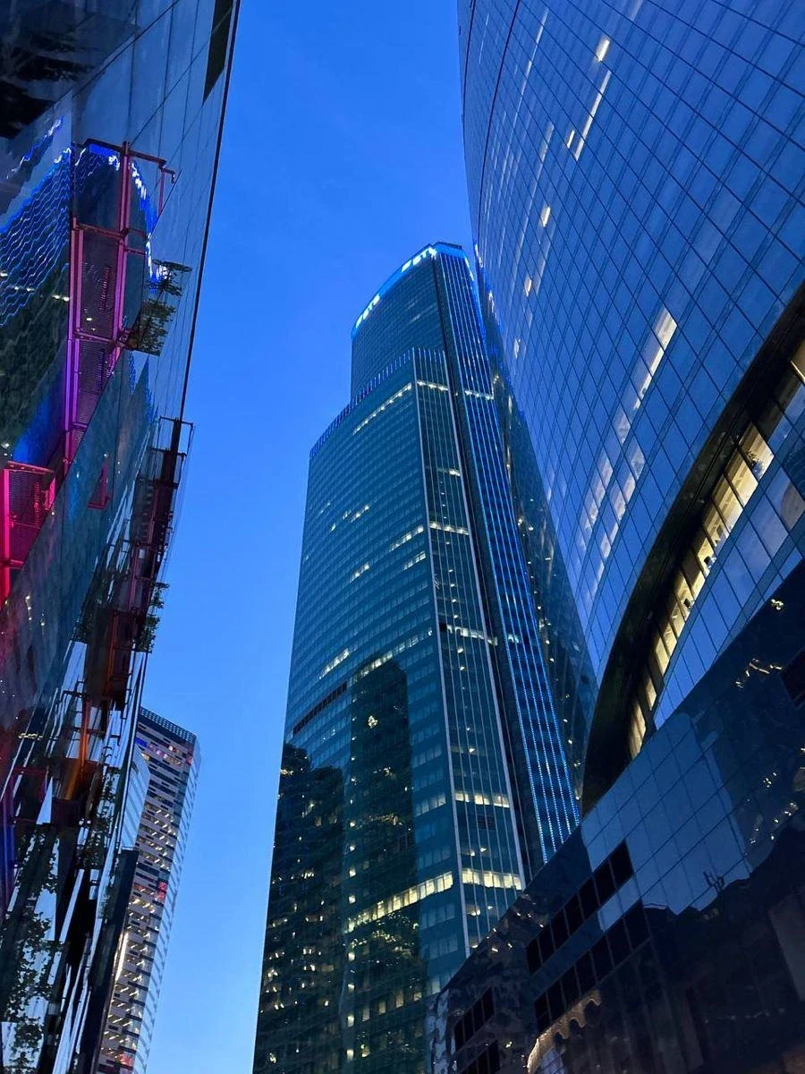 Glass office towers illuminated at dusk